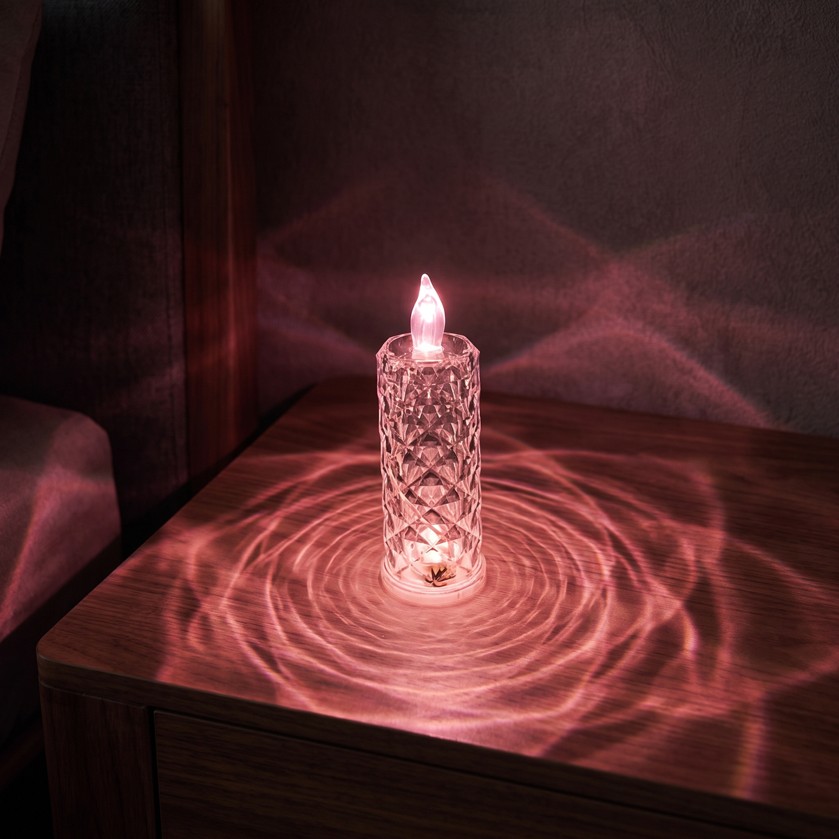 Luniee Crystal Glow Candle in pink, refracted pink light on the table and wall
