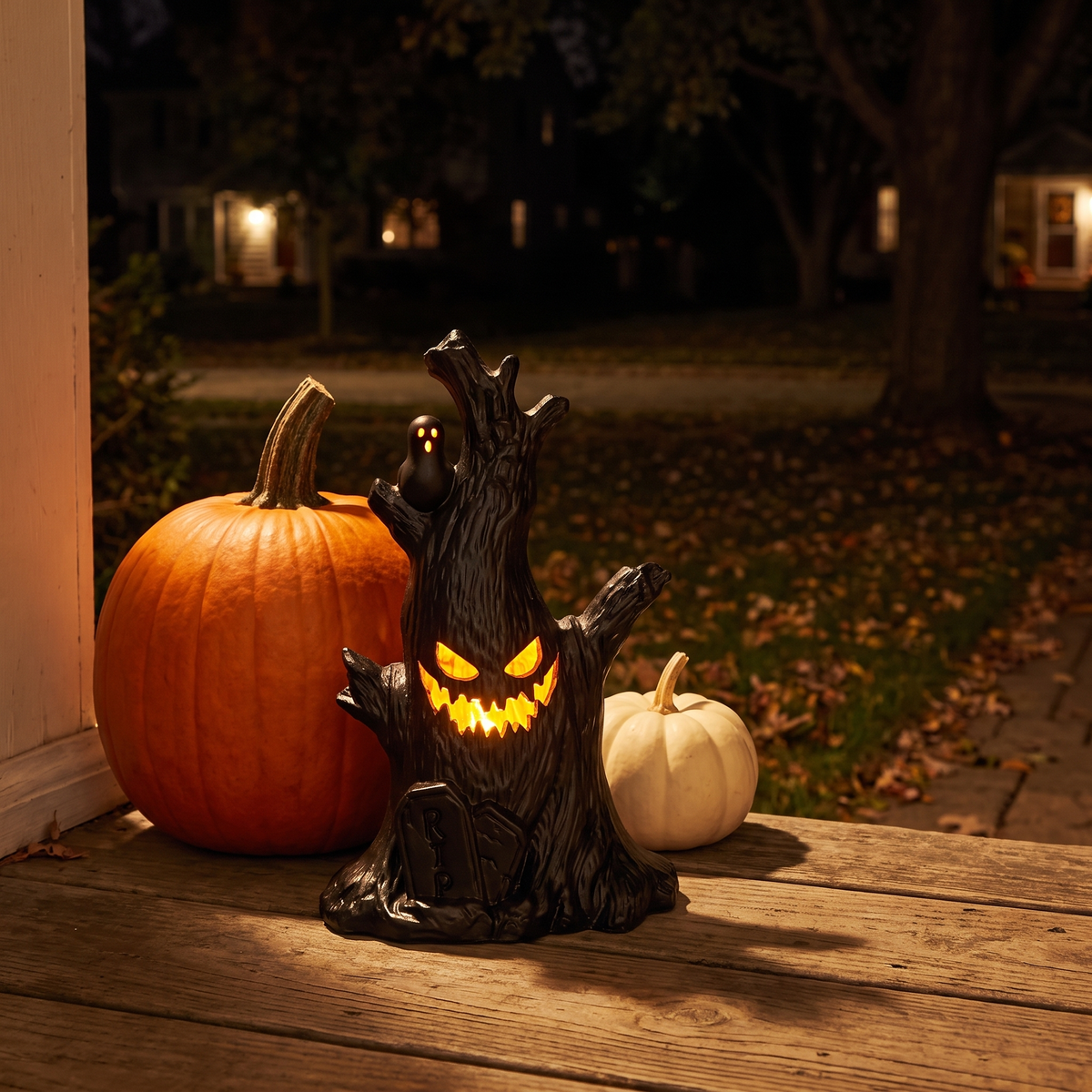 Luniee Pumpkin Lamp glowing on a porch step beside pumpkins at night